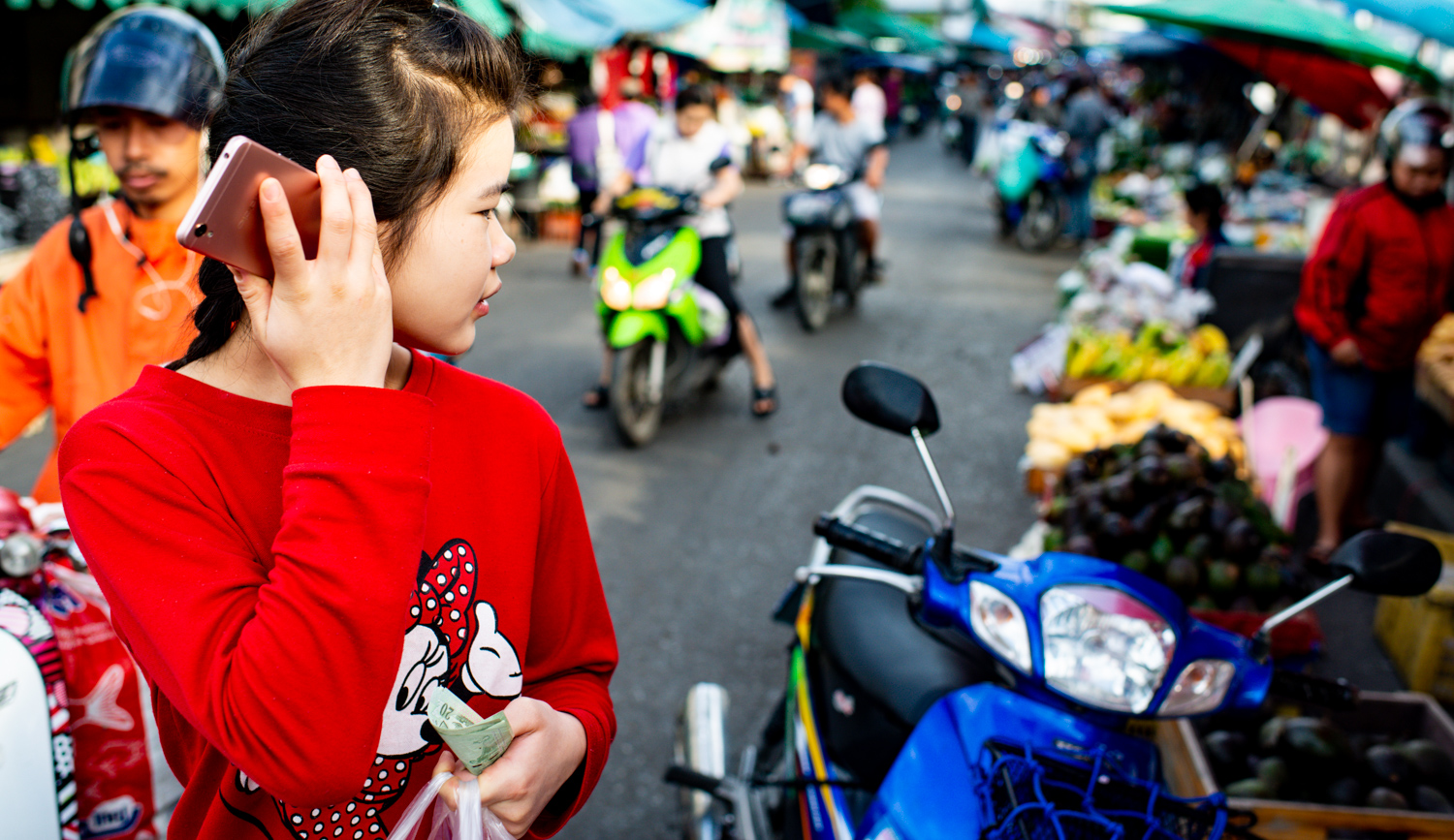 Young woman using her mobile phone at the market